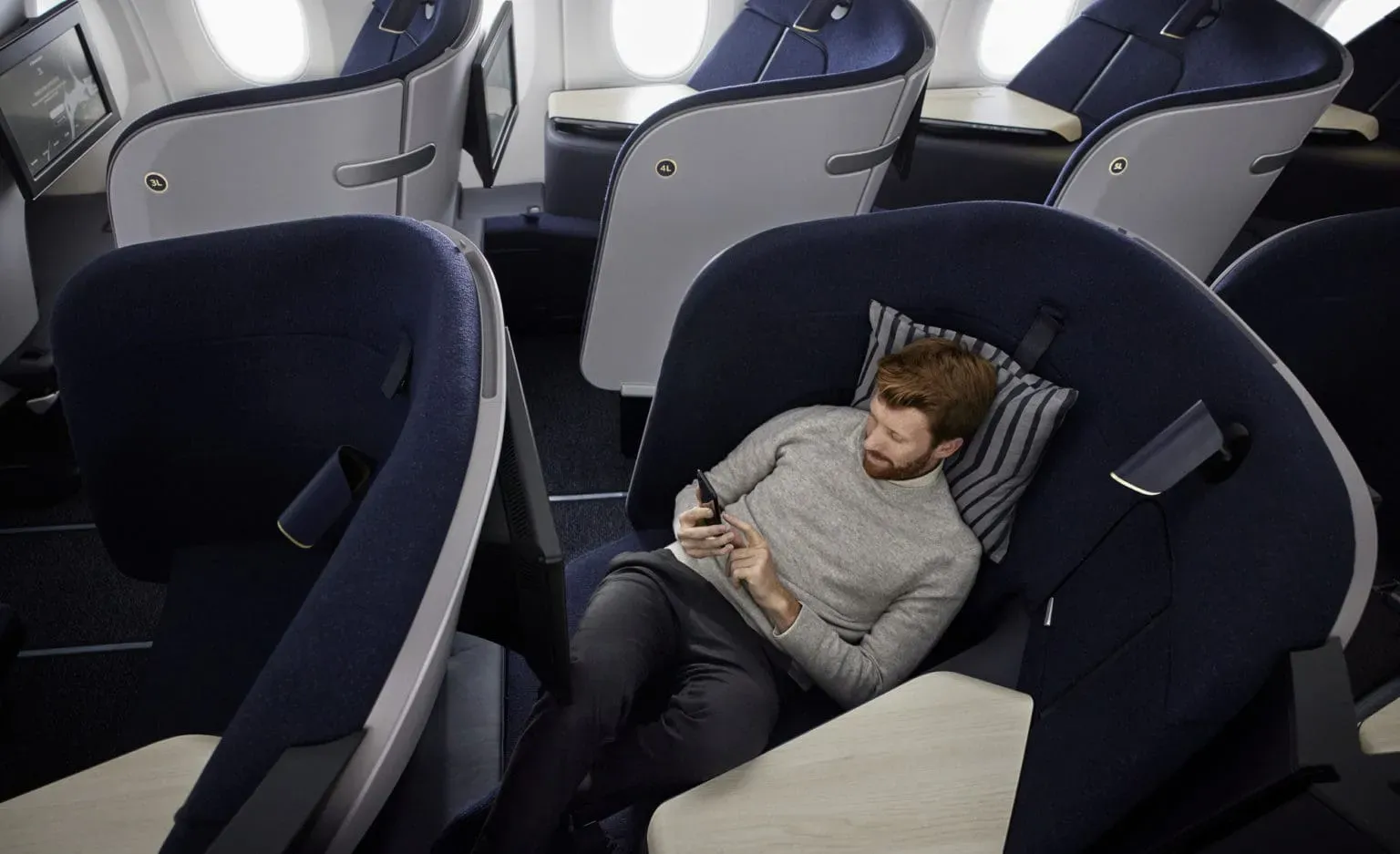 Passenger relaxing with his phone in a Finnair AirLounge business seat
