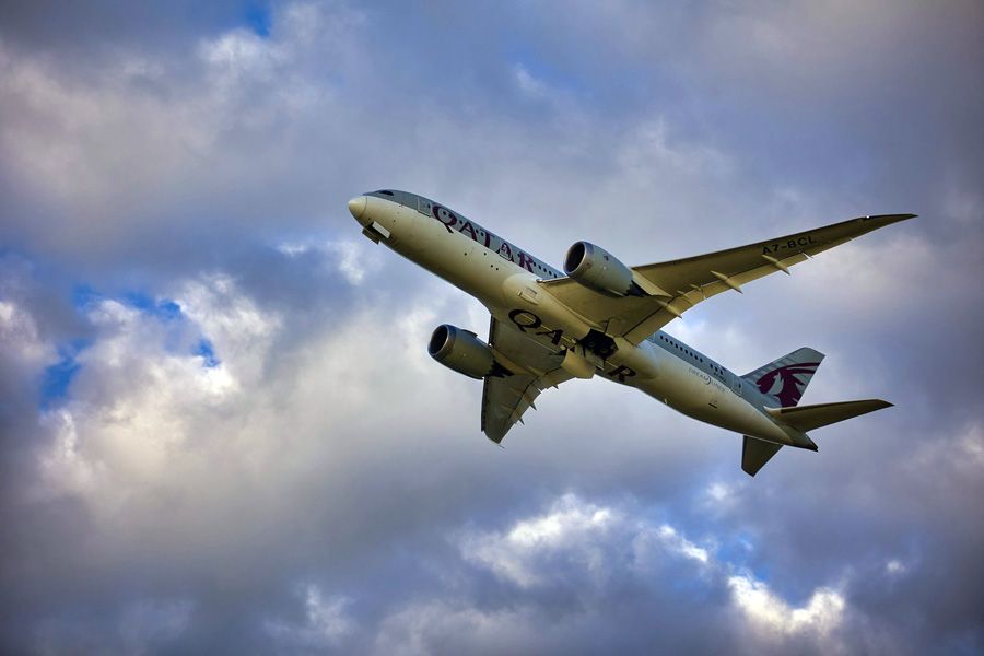 Qatar Airways Boeing 787 Dreamliner climbing against cloudy skies